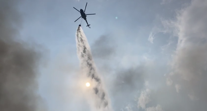 Water gushing from helicopter to control fire